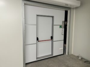 une porte de secours int&eacute;gr&eacute;e dans la porte isotherne d'une chambre froide